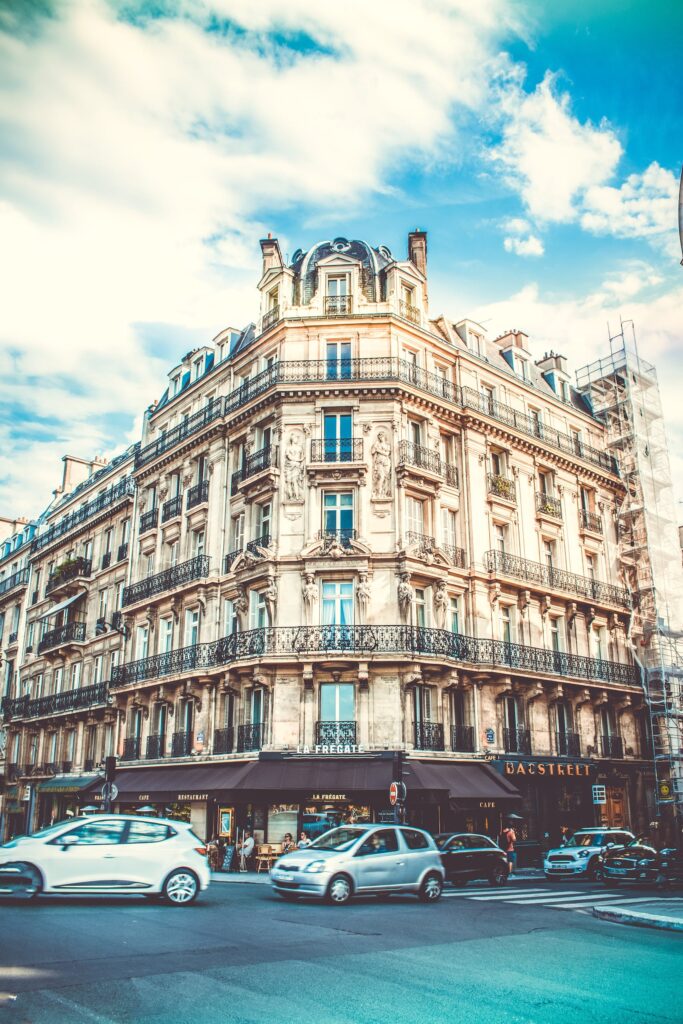 Stunning view of a classic Parisian building on a busy city street corner, capturing urban vitality.